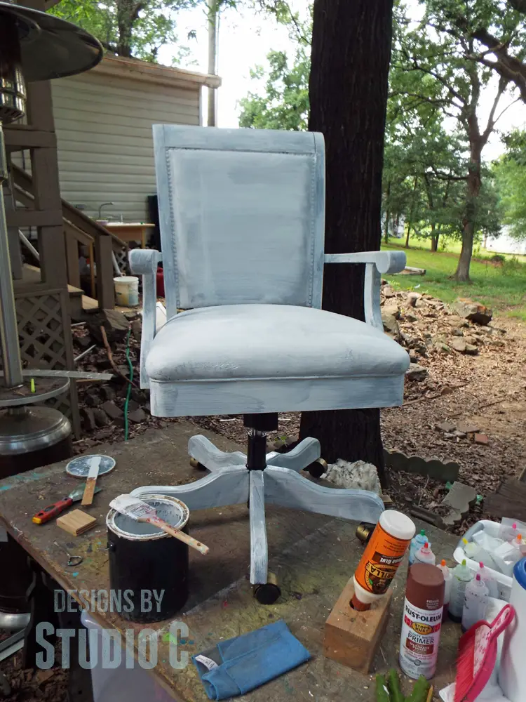 painting upholstery on a chair coated with primer