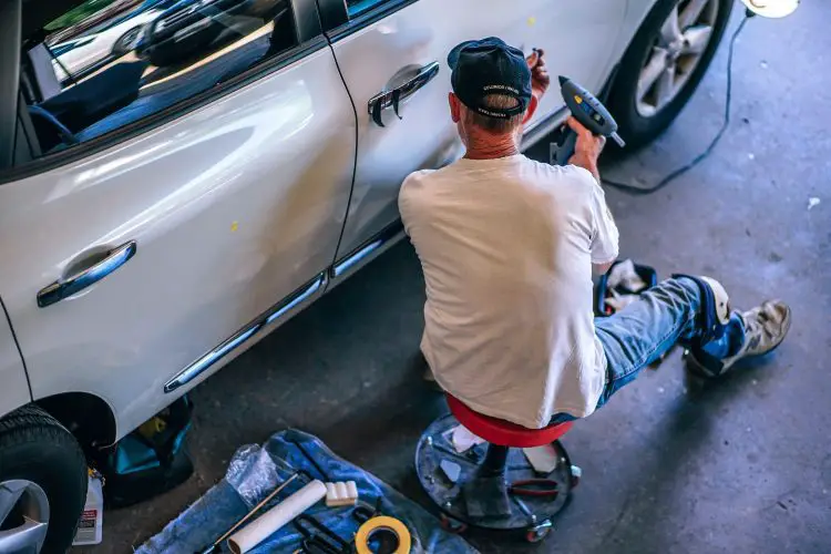 5 tips renovating garage man on floor repairing car