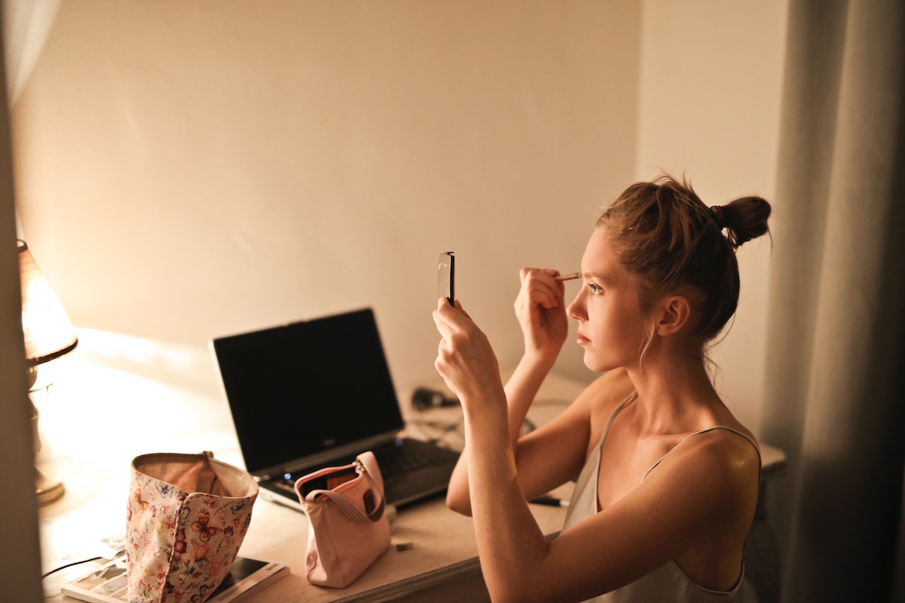 DIY makeup vanity ideas woman applying cosmetics