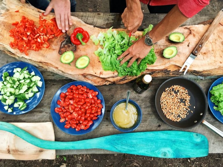 how to design an outdoor kitchen chopping vegetables on a wood cutting board