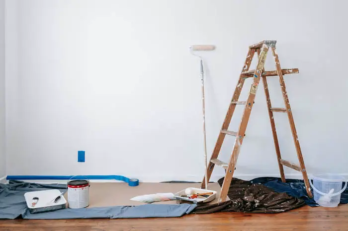 DIY home remodeling ladder with paint roller and supplies