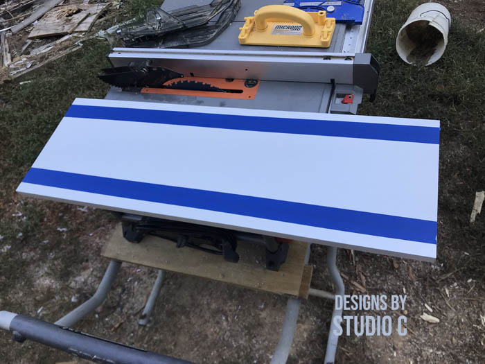 how to make a work table out of a base cabinet using blue tape on apron where cuts are made