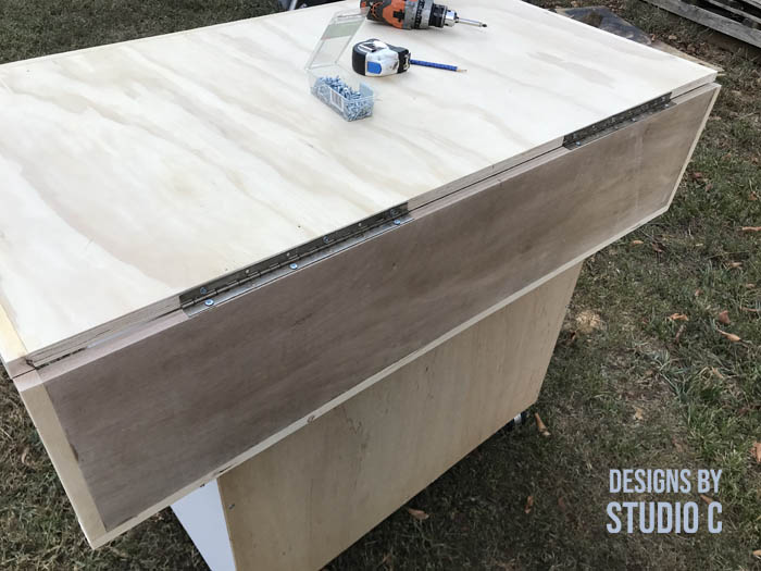 how to make a work table out of a base cabinet using a piano hinge cut in half to secure the leaf